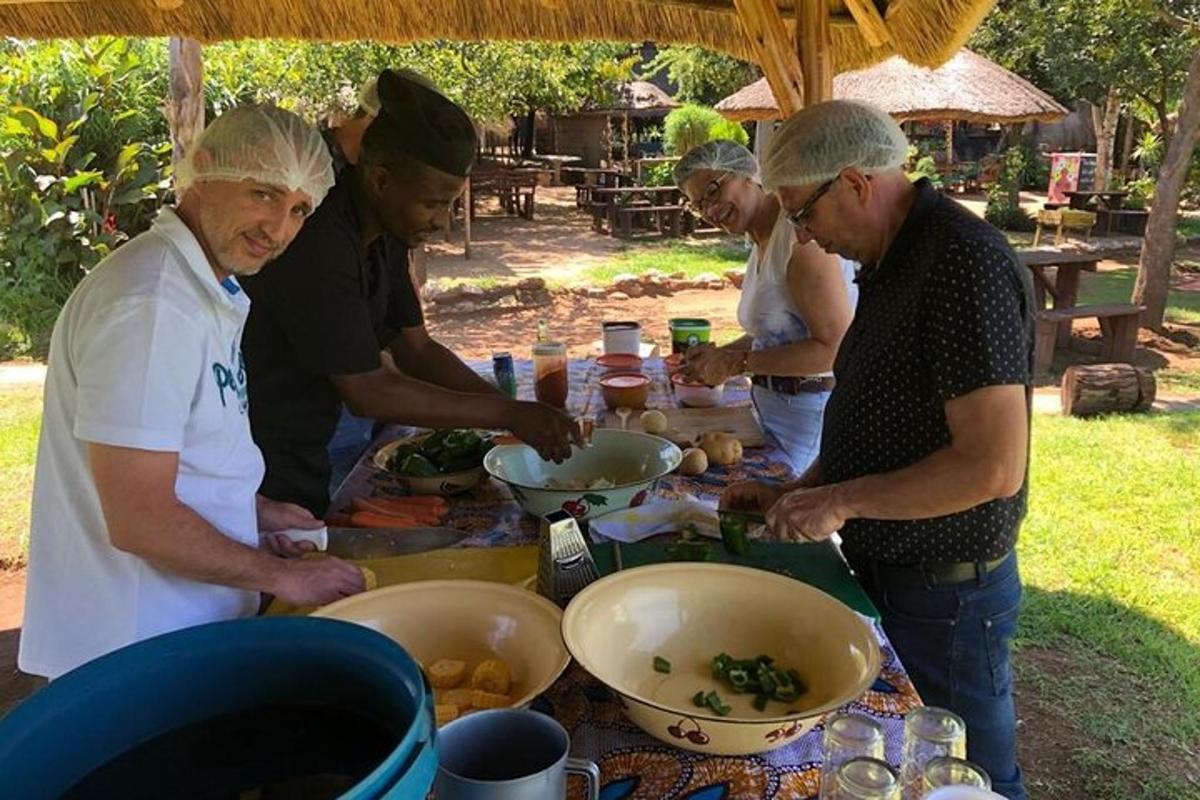 un gruppo di uomini in piedi attorno a un tavolo che preparano il cibo