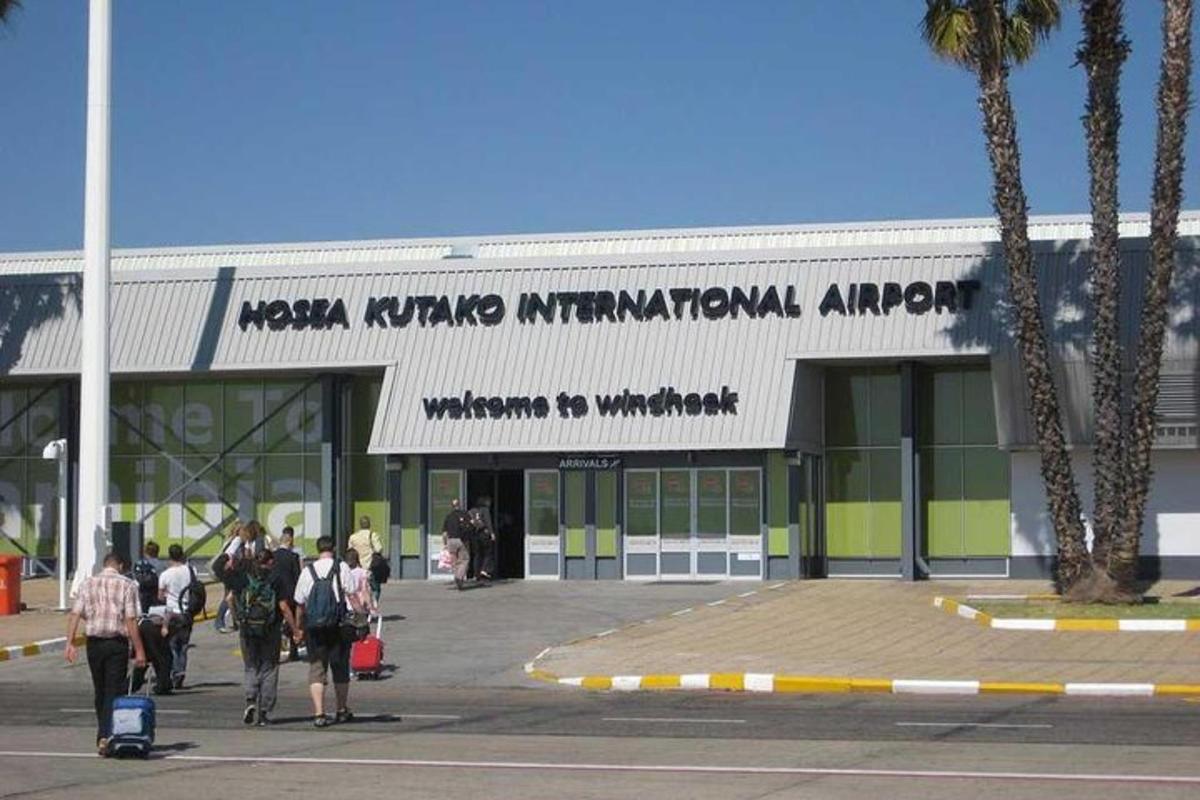 a group of people walking in front of an airport