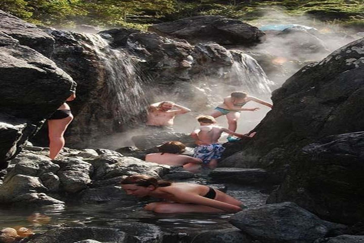 un gruppo di persone in acqua vicino a una cascata