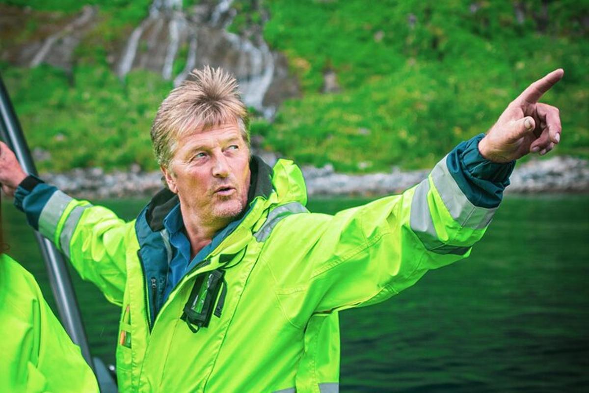 Maður í gulum jakka stendur í vatninu