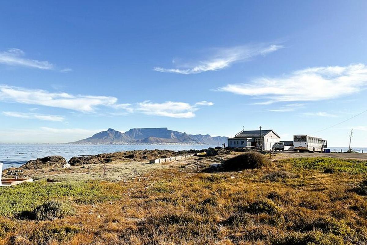 et hus på en strand med havet og bjergene