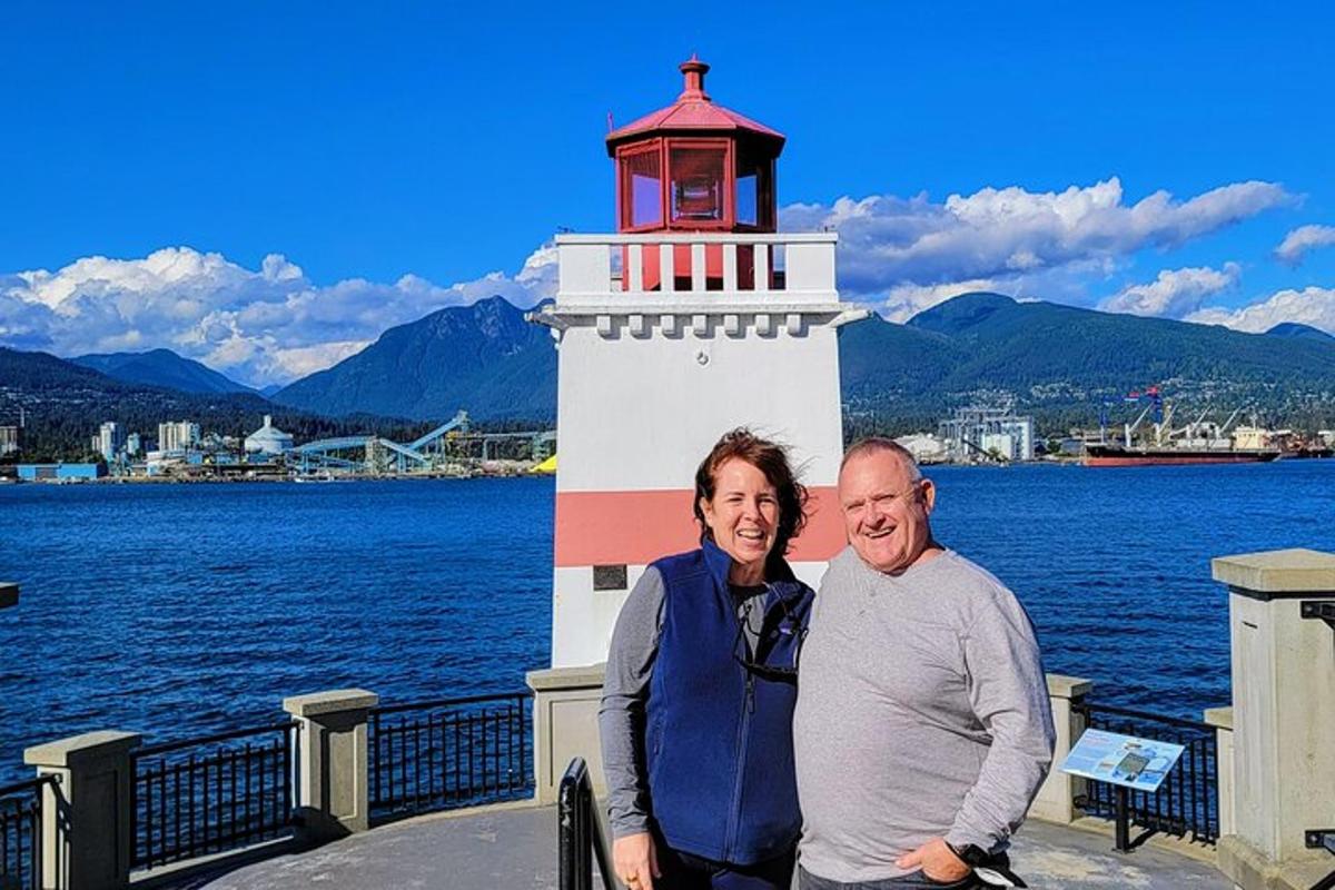 a man and woman standing in front of a lighthouse