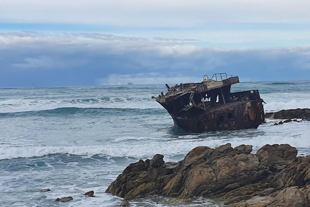 una barca ferma nell'oceano accanto ad alcune rocce