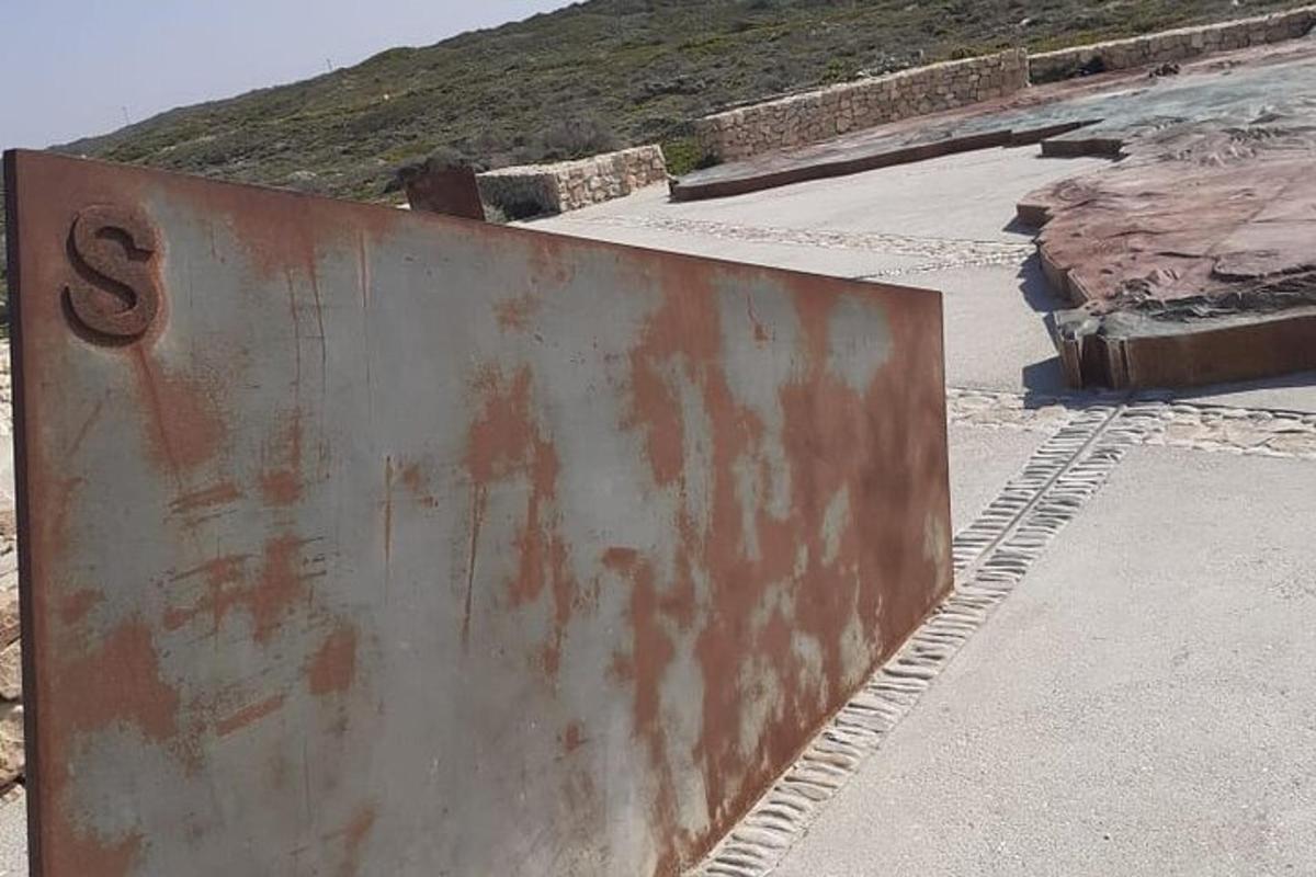 un cartello arrugginito sul ciglio di una strada