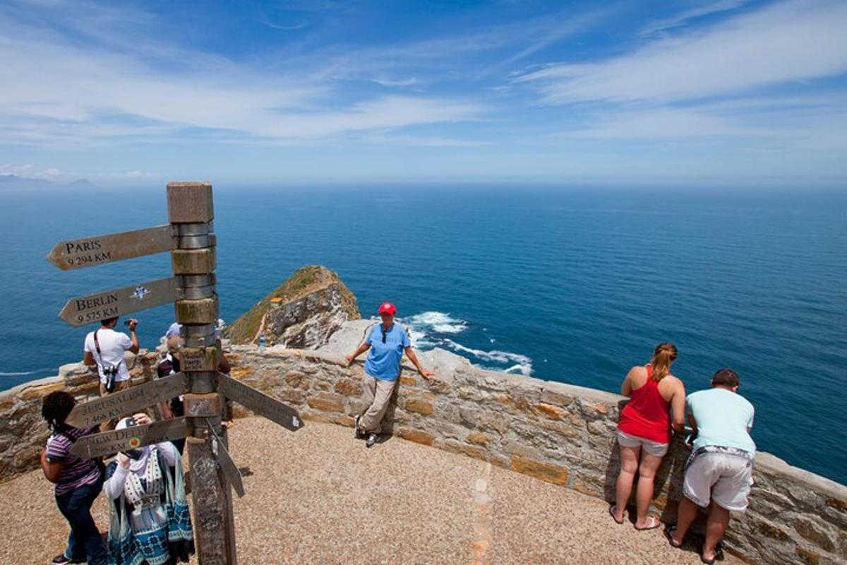 eine Gruppe von Menschen steht auf einer Klippe mit Blick auf den Ozean