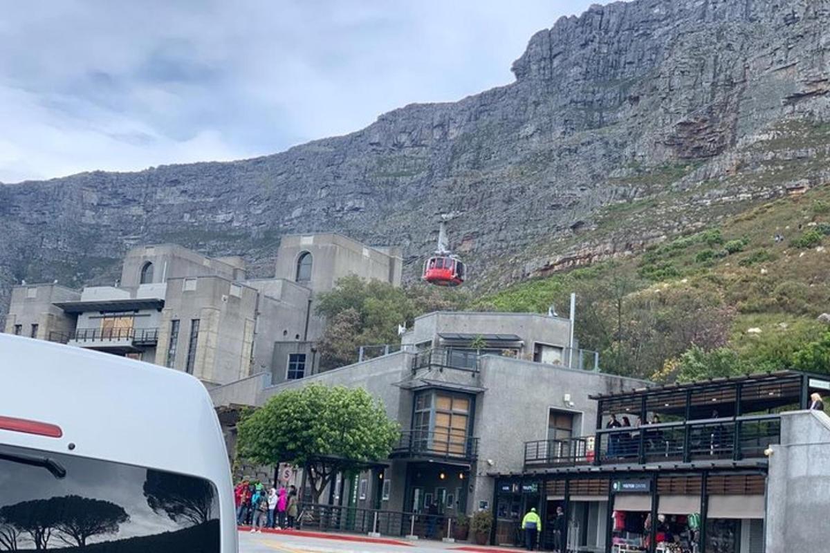 ein Gebäude mit einem Berg im Hintergrund mit einer roten Straßenbahn