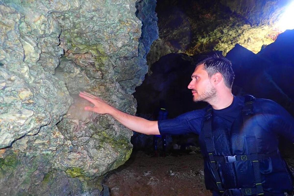 um homem parado em uma caverna com a mão estendida