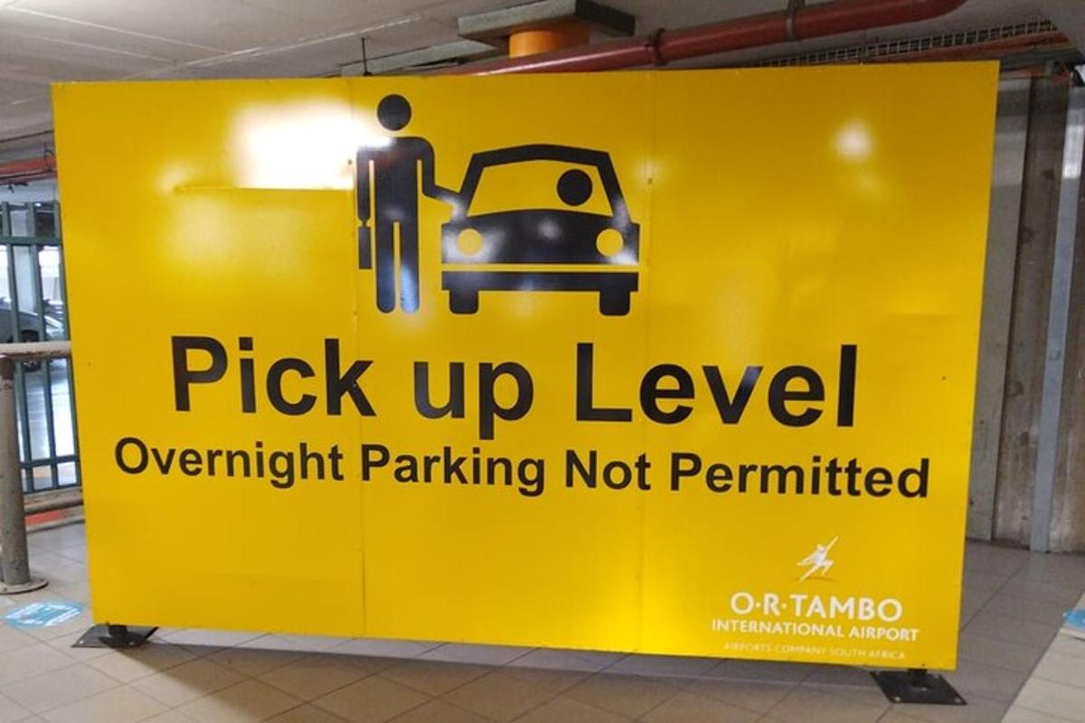 a yellow sign that reads pick up level overnight parking not permitted