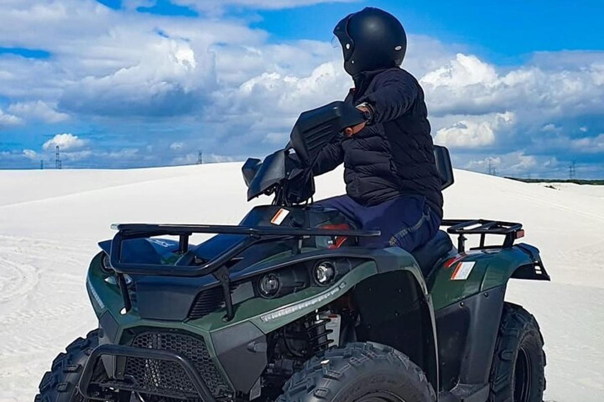 seseorang yang duduk di atas atv di dalam pasir