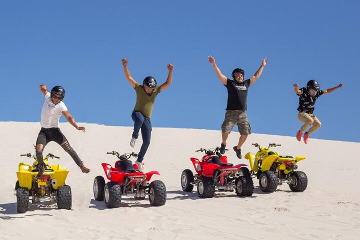 en gruppe mænd hopper i sandet med ATV'er