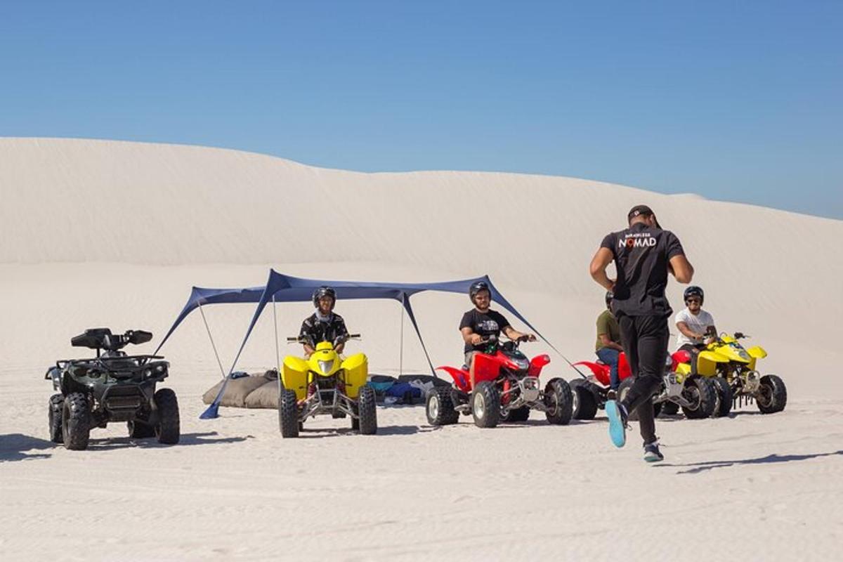 sekelompok orang di atas ATV di padang pasir