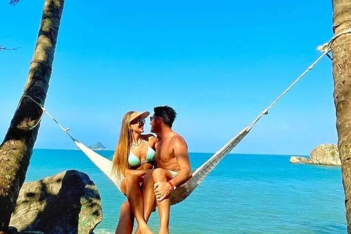 una coppia seduta su un'amaca sulla spiaggia