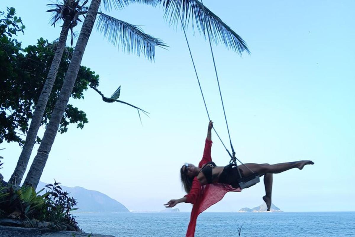 một người đàn ông trên xích đu dây thừng trên bãi biển
