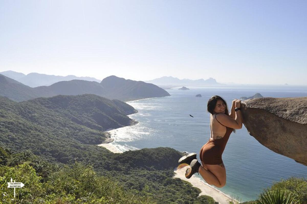 una donna in bikini seduta su una roccia con vista sull'oceano