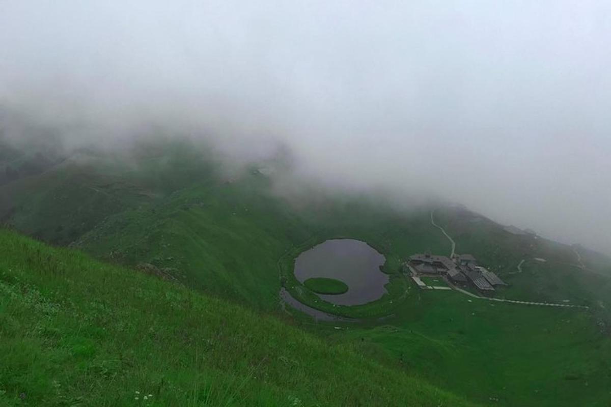 a foggy hill with a crater in the middle of a field
