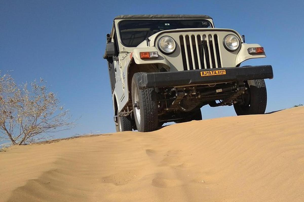a jeep parked on top of a sand hill