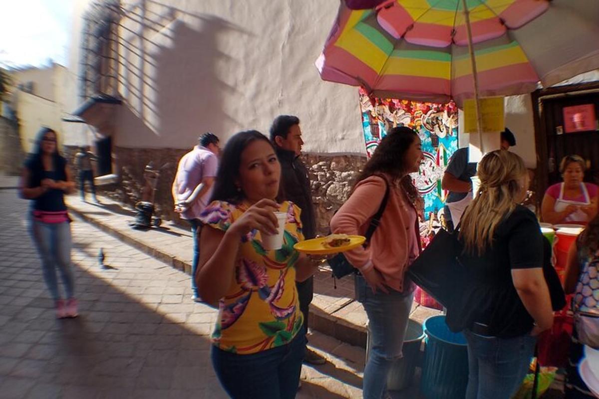 a group of women walking down a street with an umbrella