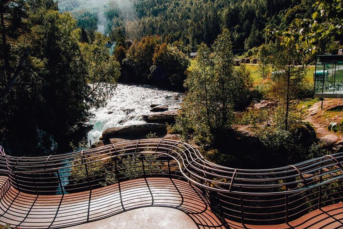 a wooden bench next to a river with a waterfall
