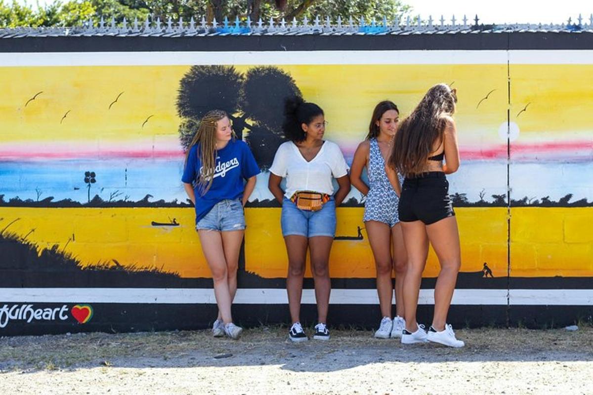quatro meninas estão em frente a um mural