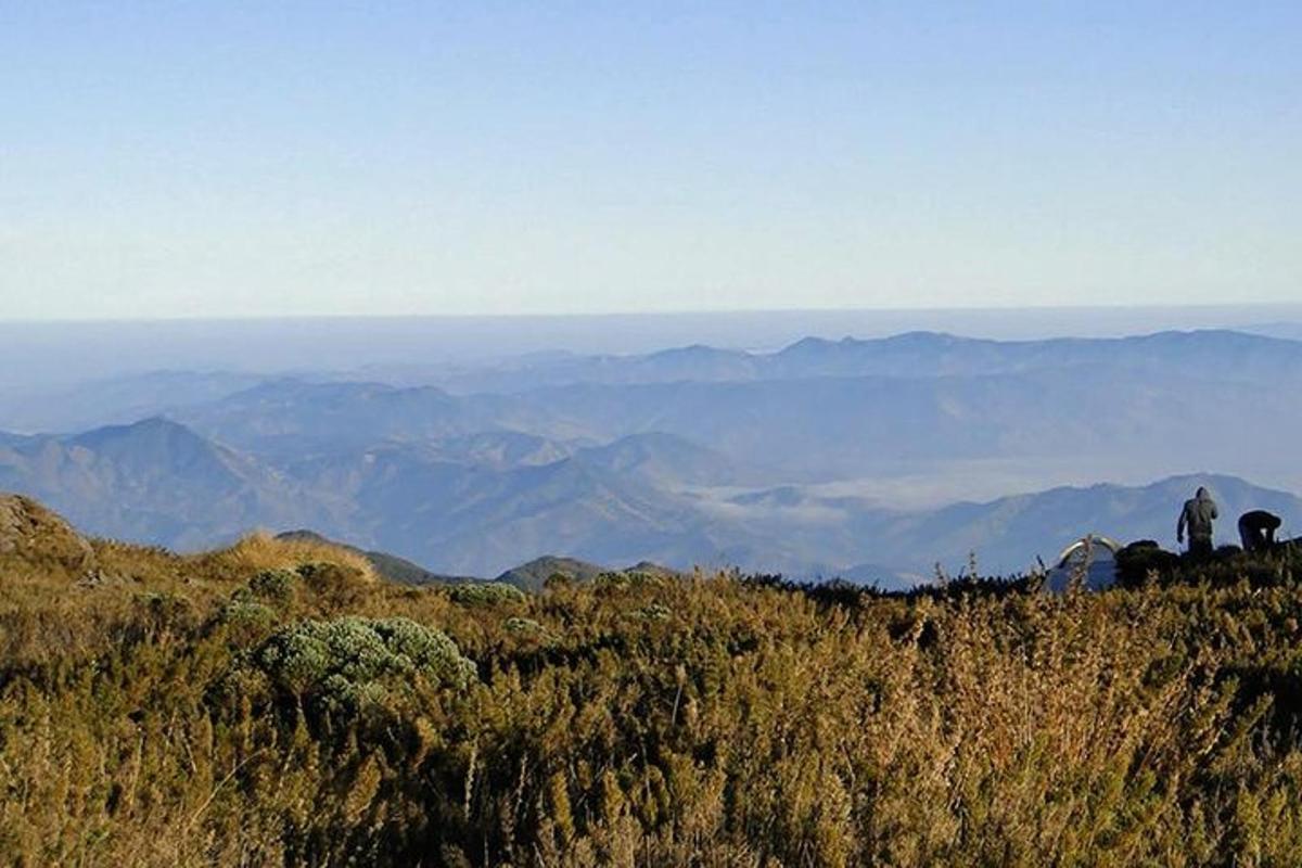 duas pessoas em pé no topo de uma montanha com vista