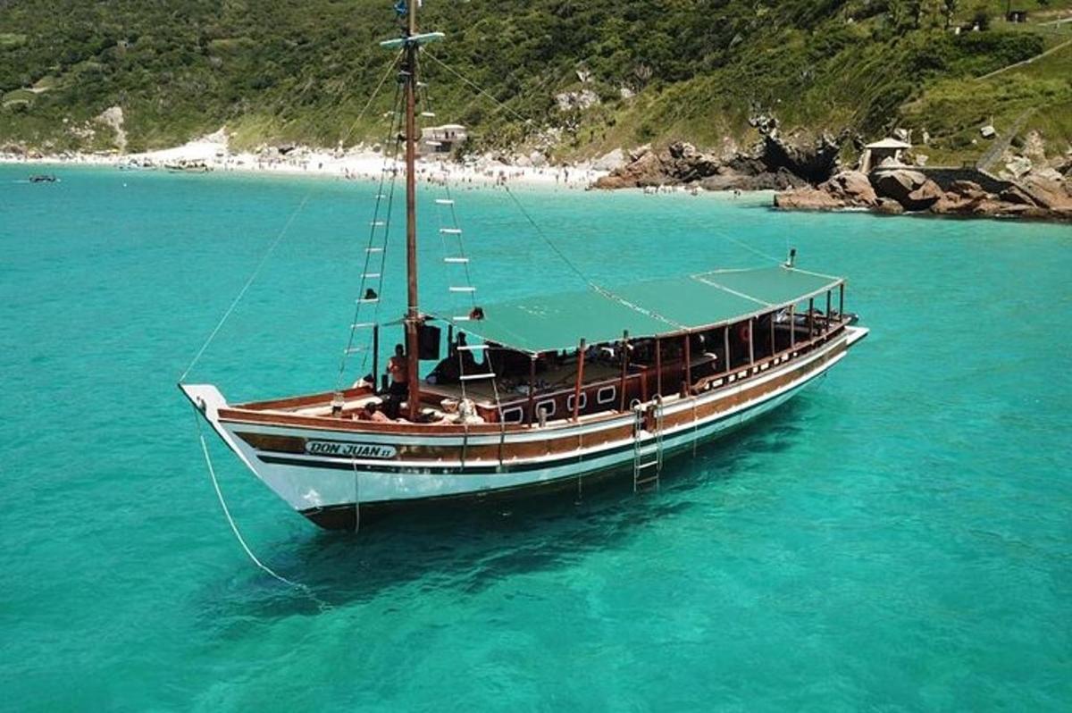 a boat sitting in the water near a beach