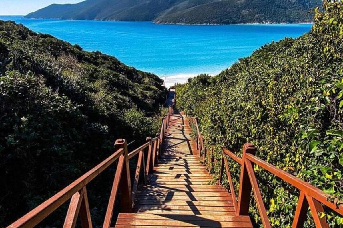 a wooden staircase leading to a beach with the ocean