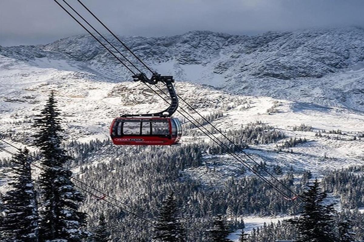 a ski lift flying over a snow covered mountain