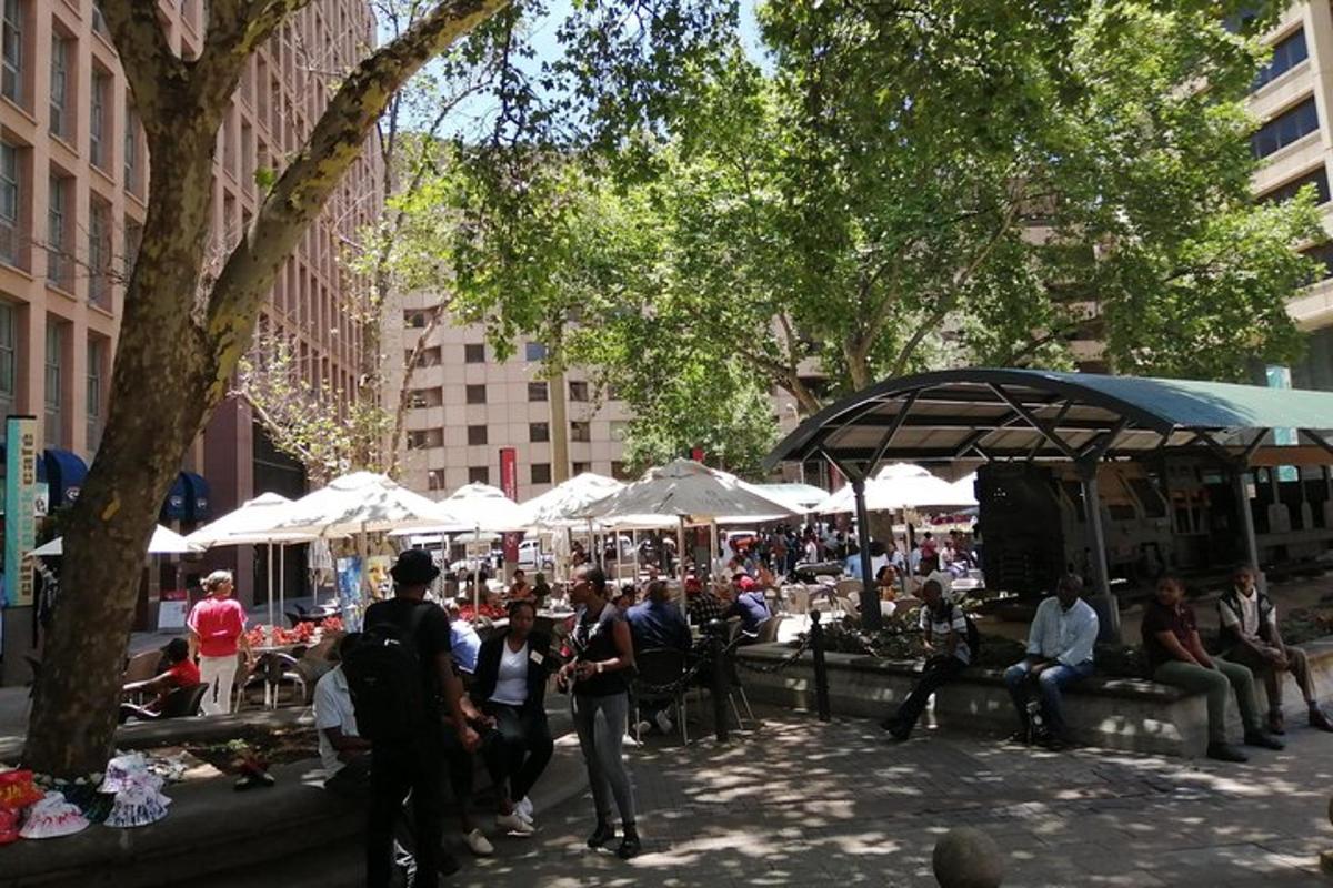 a group of people standing around a market in a city