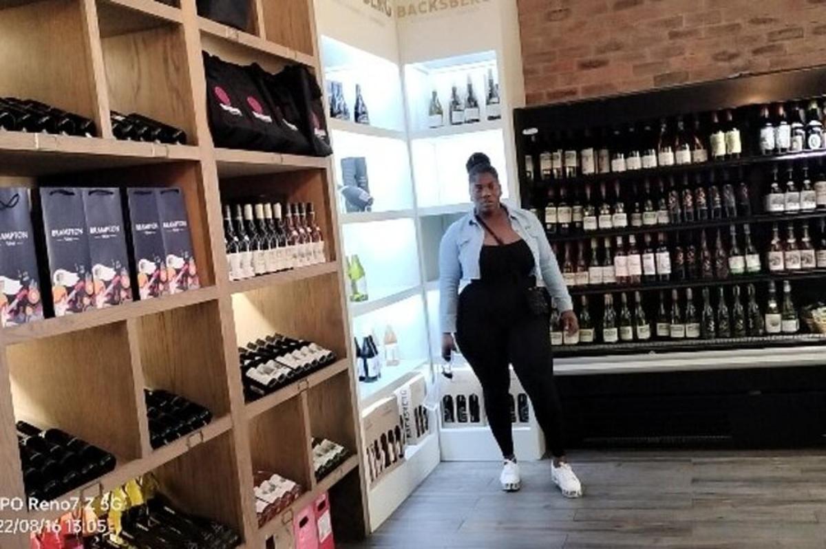 a woman is standing in a wine shop