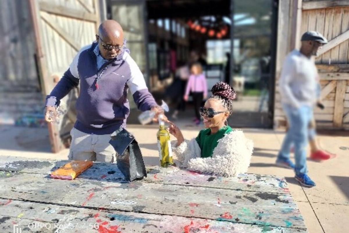 a man and a woman playing with paint on a table