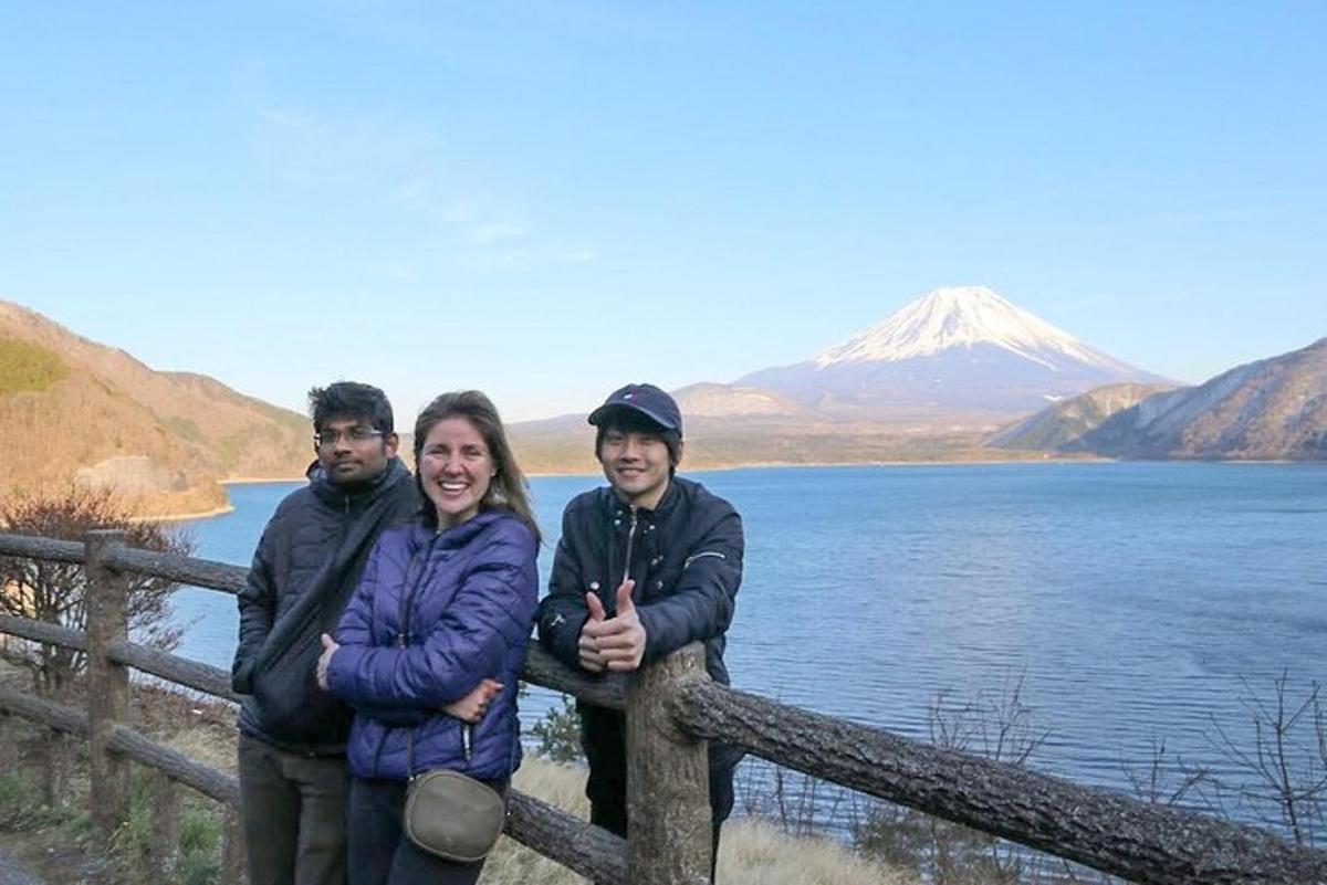 a group of people standing on a fence near a mountain