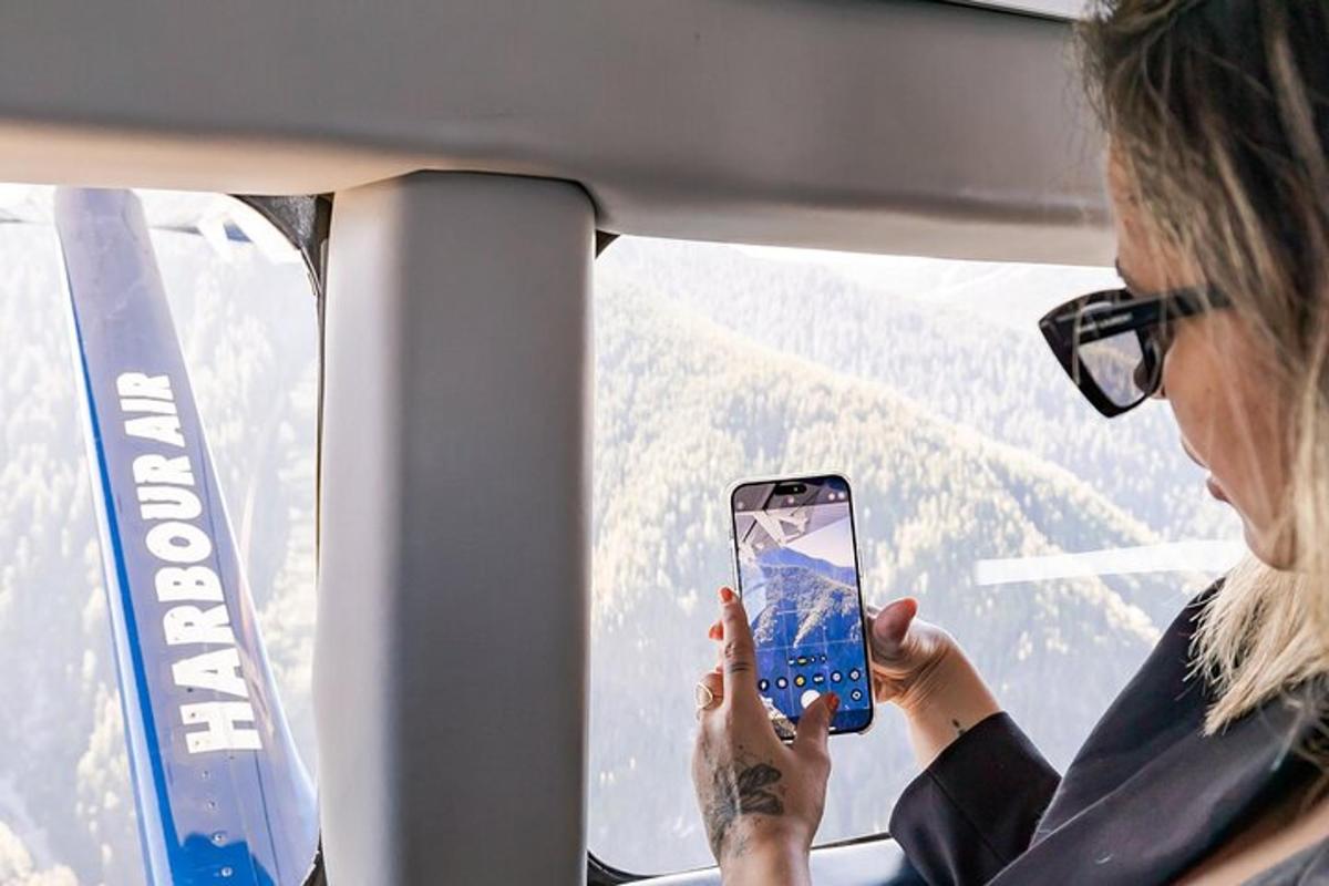 en kvinne som holder opp en mobiltelefon i en bil