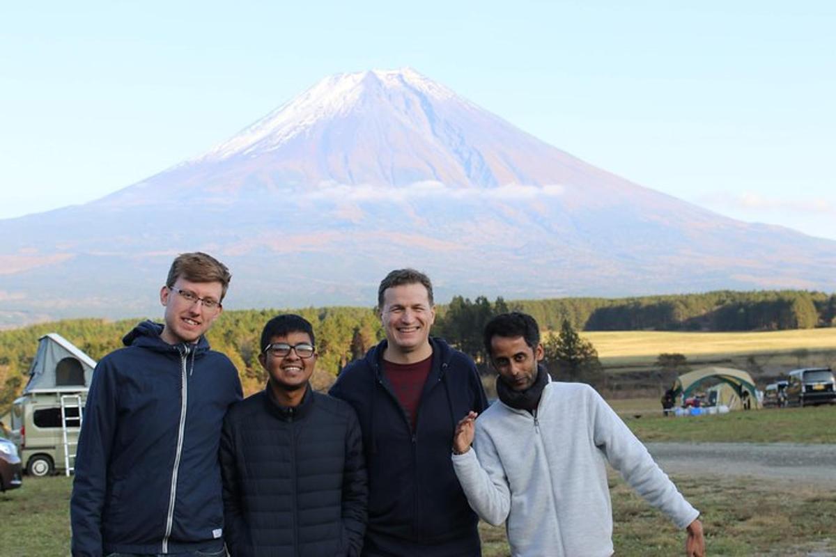 a group of men standing in front of a mountain