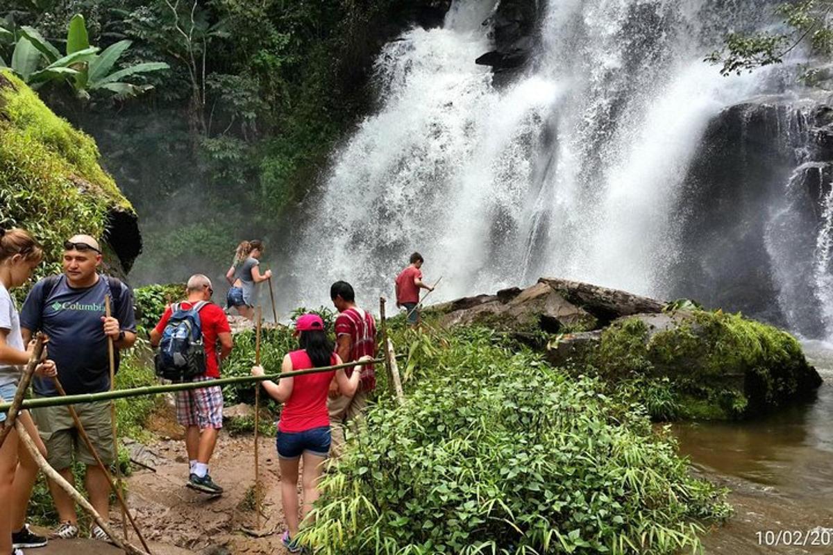 eine Gruppe von Menschen steht vor einem Wasserfall