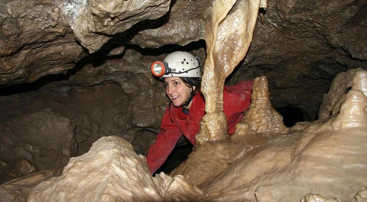 a man wearing a helmet in a cave