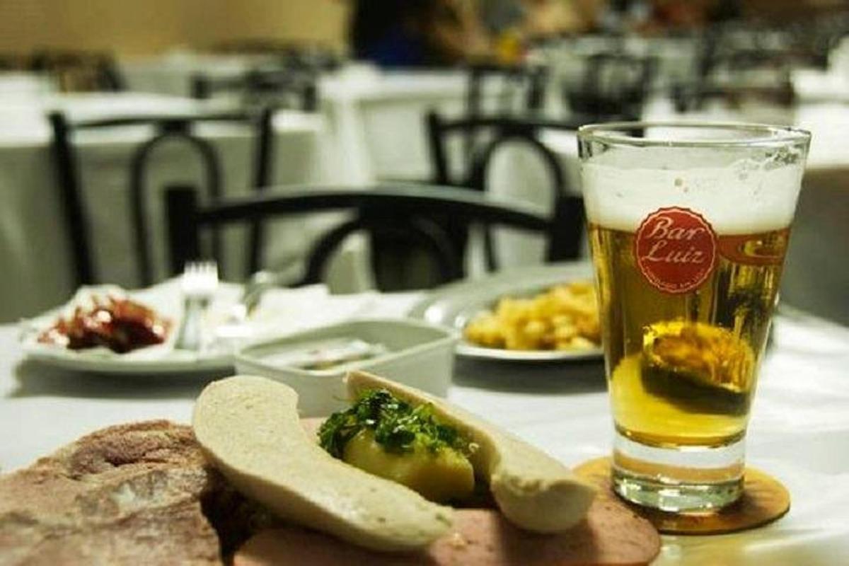 un tavolo con un bicchiere di birra e un piatto di cibo