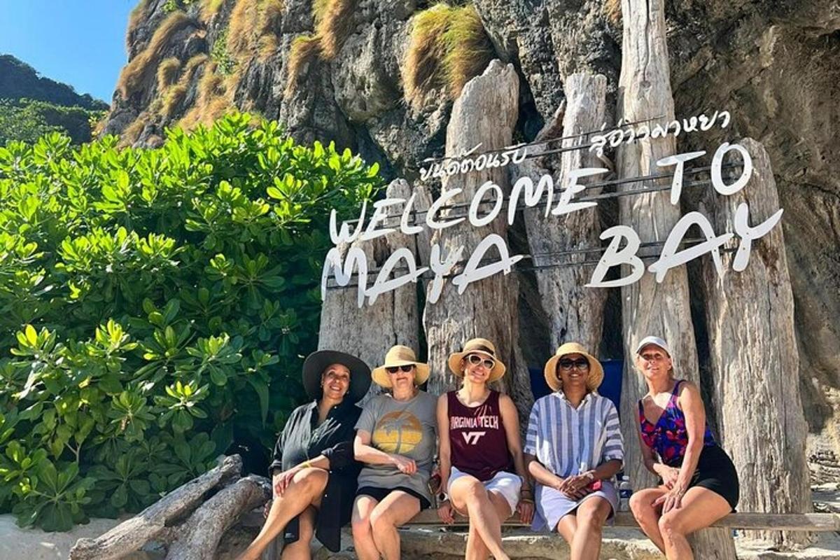 Skupina lidí sedících před cedulí „Vítejte v Maya Bay“