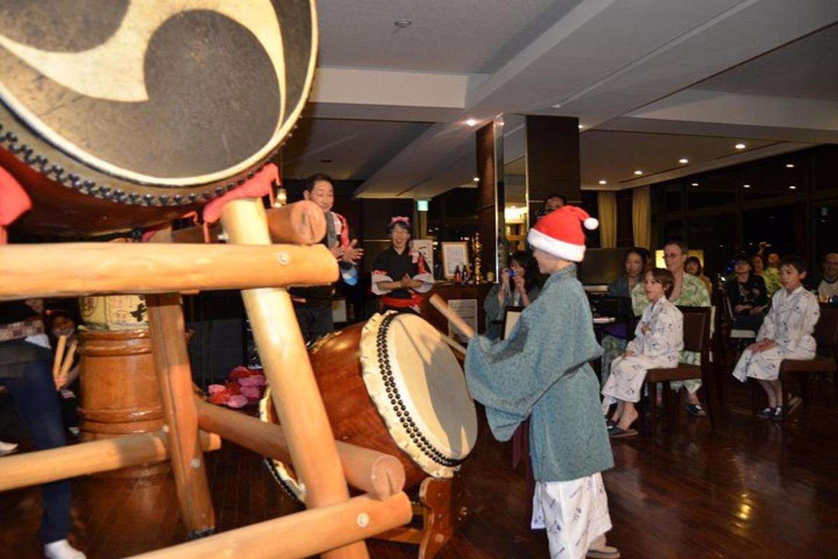 a woman in a santa hat playing a drum