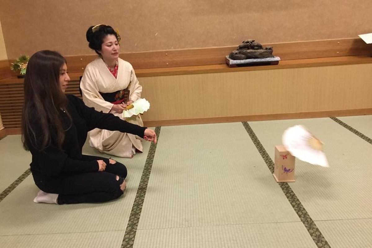 two women sitting on the floor looking at a kite