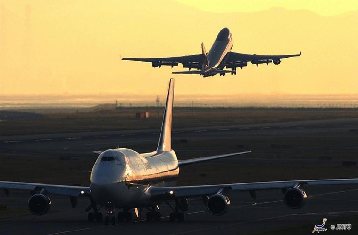two planes are taking off from an airport runway