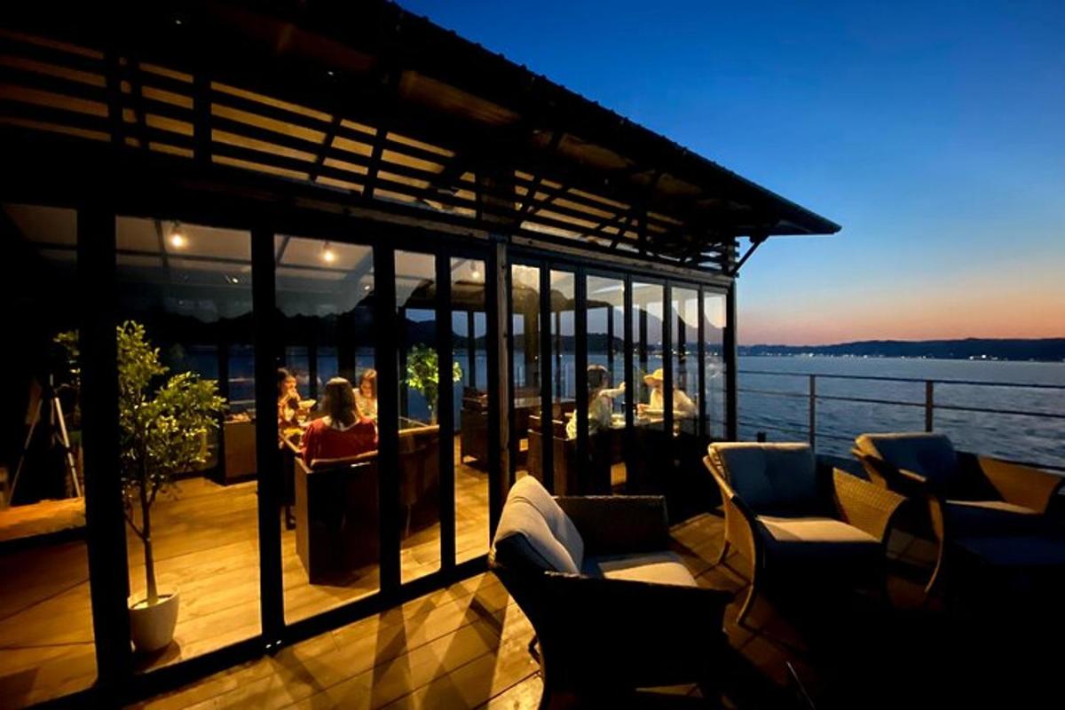 a deck with chairs and people on the water