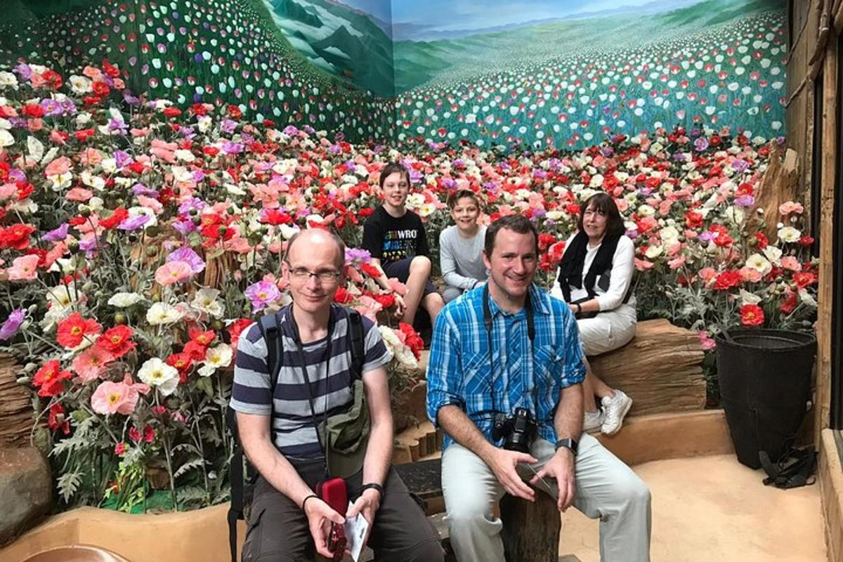un gruppo di persone sedute davanti a un murale di fiori