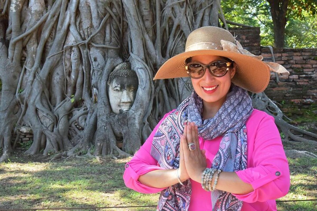 una donna con un cappello in piedi davanti a un albero