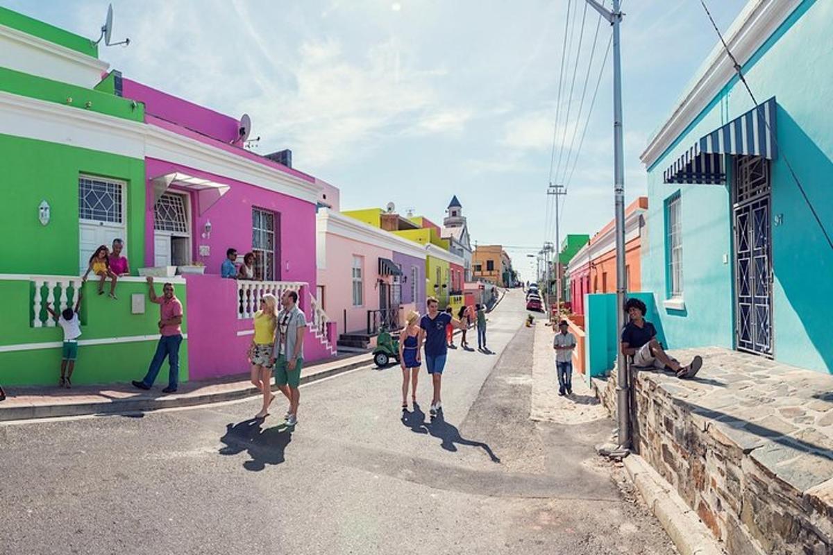 un grup de persones caminant per un carrer amb edificis de colors