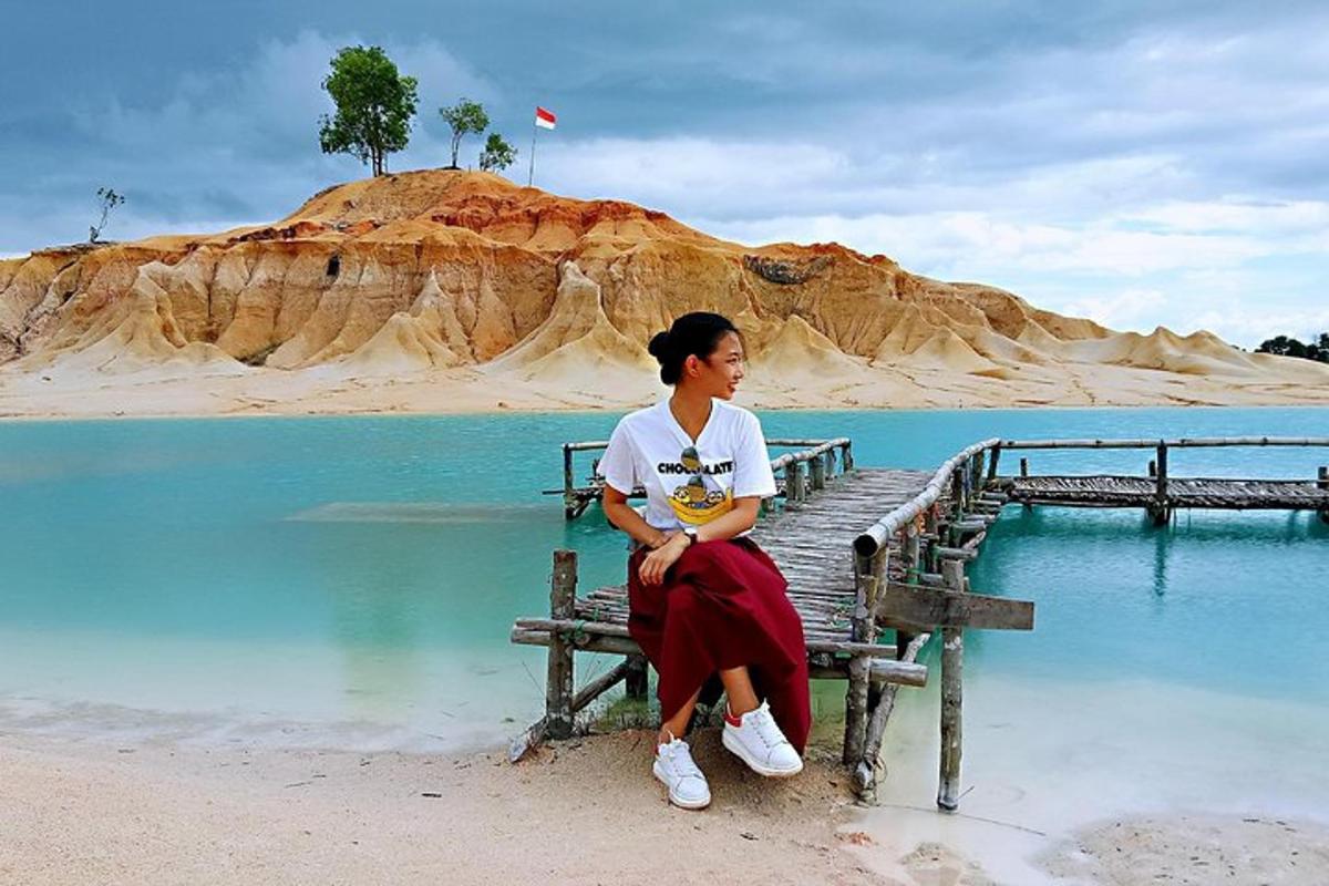a woman sitting on a bench next to a body of water