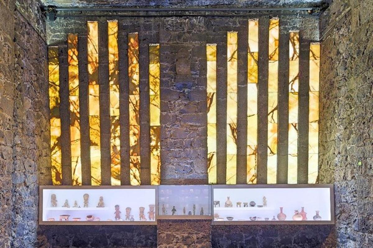Una ventana en una pared de ladrillos con figuras en exhibición.