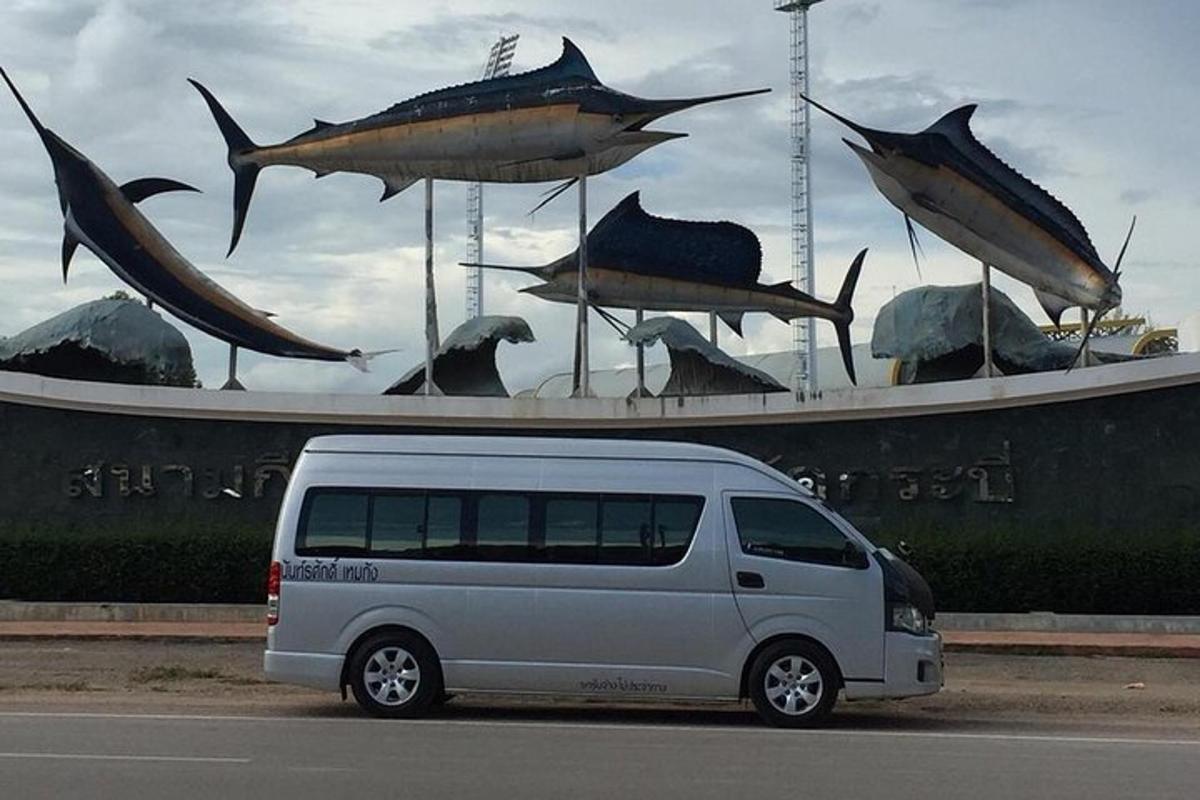 a van parked in front of a sculpture of fish