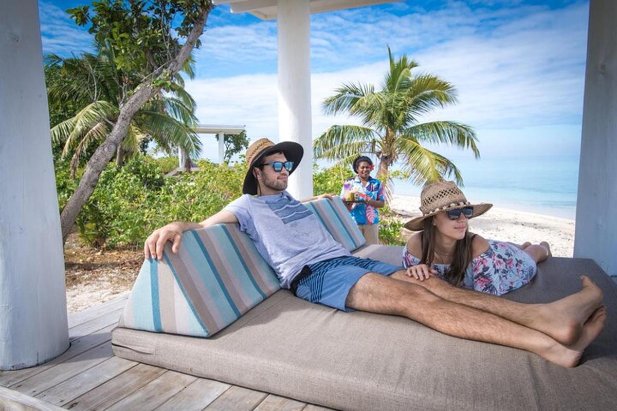 a man and a woman sitting on a couch on the beach