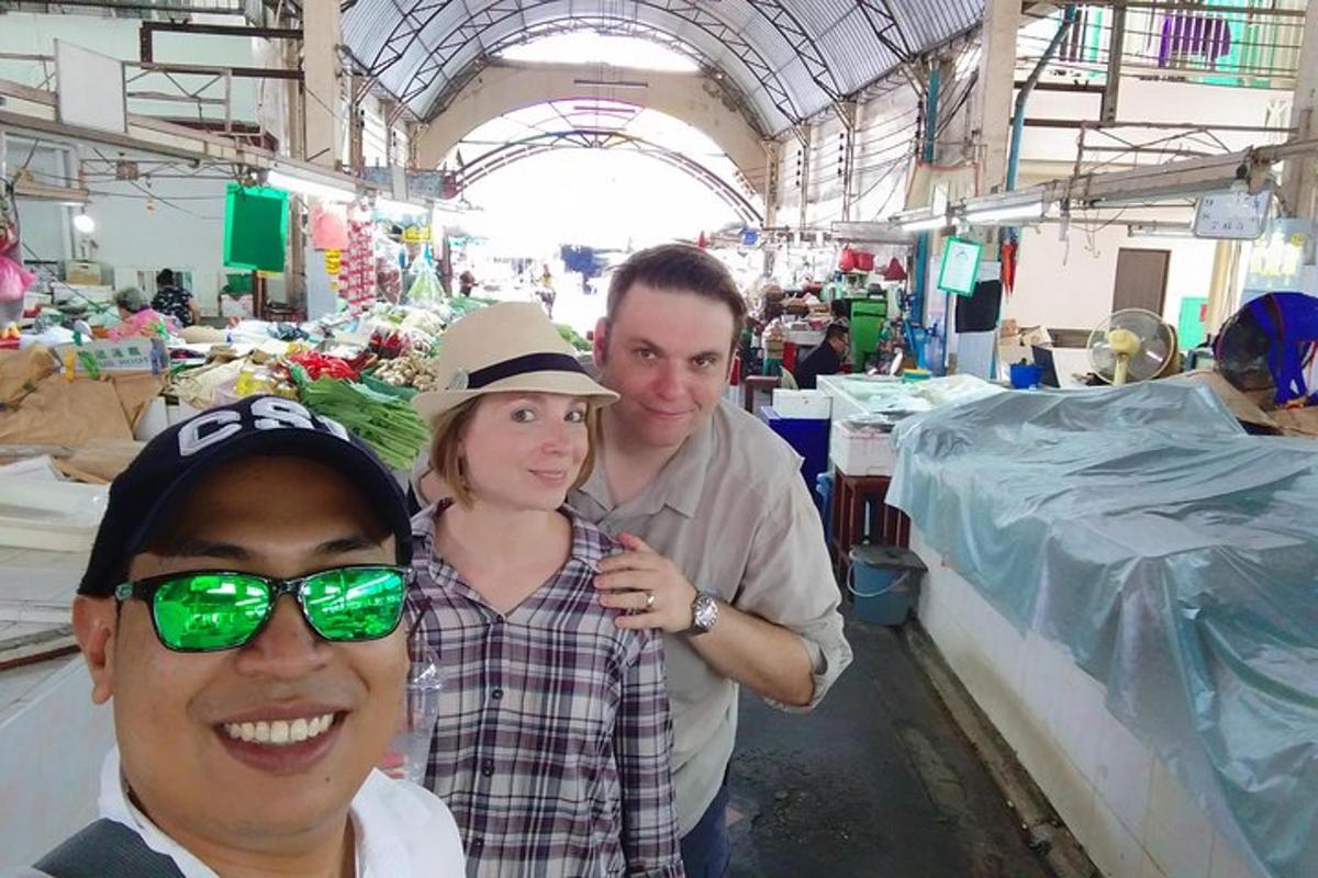 Un hombre y una mujer posando para una foto en un mercado.