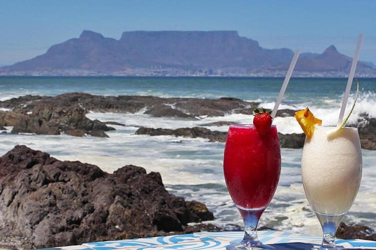 hai ly cocktail ngồi trên bãi biển với đại dương